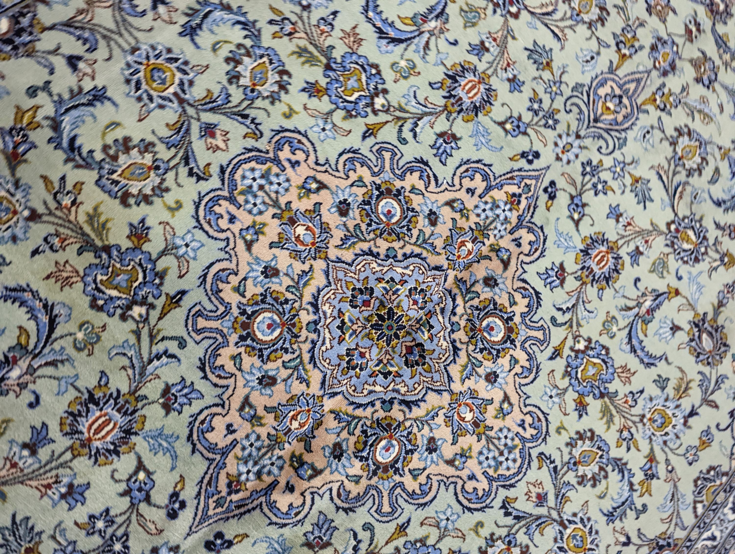 A Kashan pale green ground carpet, 410 x 296cm